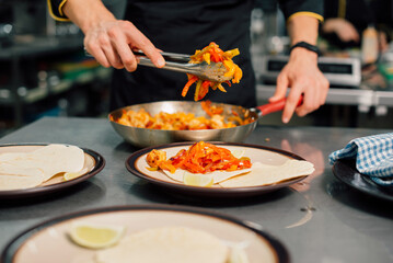A skilled chef expertly puts together delicious, fresh tacos within a colorful, vibrant kitchen...