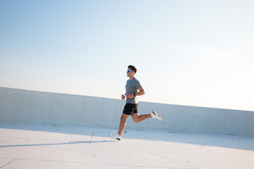 Runner enjoying a morning jog on a rooftop under clear blue skies