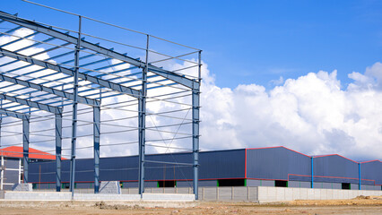 Obraz premium Metal structure of industry building with factory warehouses in construction site against blue sky background, Perspective side view with copy space