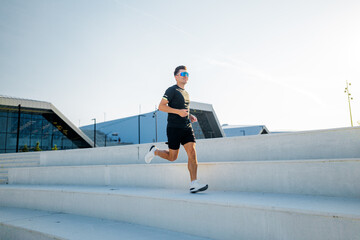 Runner enjoying a sunny day while sprinting up modern outdoor steps