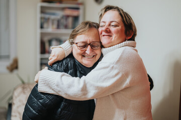 Senior woman and young adult engaging in a heartfelt hug, showcasing affection and closeness in a...