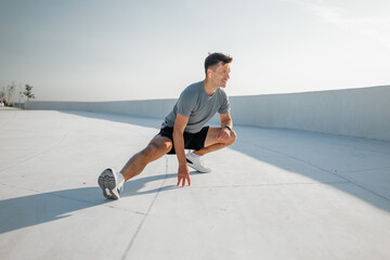 Dynamic stretch practice on a sunlit rooftop during early morning hours