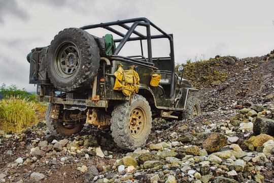 Jeep stuck on gravel during off-road adventure at Mount Merapi in Indonesia.