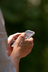 A person is currently holding a cell phone securely in their hands, indicating their engagement...