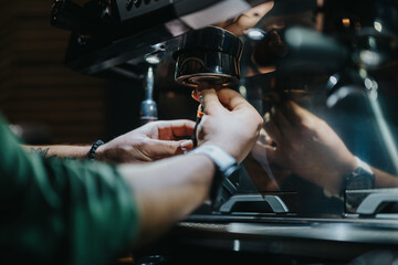 A barista operates a coffee grinder, preparing espresso in a professional coffee-making...