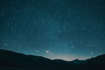 a night sky with a shooting star and a shooting star
