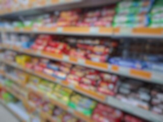 Blurry image of a supermarket aisle with shelves full of products. An abstract retail background...