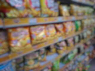 Blurry image of a supermarket aisle with shelves full of products. An abstract retail background for business, shopping, supermarket concepts, or consumer markets.