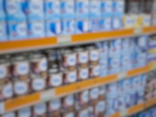 Blurry image of a supermarket aisle with shelves full of products. An abstract retail background...