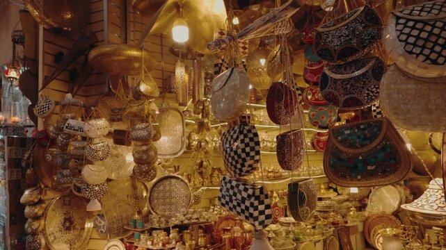 This vibrant stall in a Moroccan souk displays an array of beautiful handcrafted goods. Metal teapots, plates, and purses decorated with colorful stones and patterns. essence of Moroccan craftsmanship