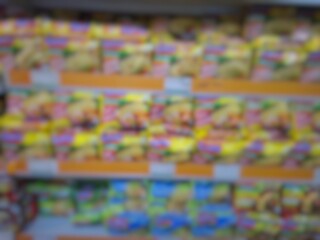 Blurry image of a supermarket aisle with shelves full of products. An abstract retail background for business, shopping, supermarket concepts, or consumer markets.