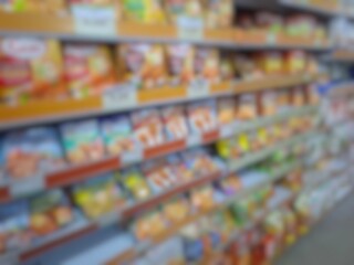 Blurry image of a supermarket aisle with shelves full of products. An abstract retail background for business, shopping, supermarket concepts, or consumer markets.