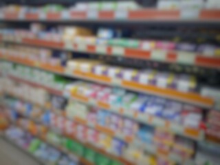 Blurry image of a supermarket aisle with shelves full of products. An abstract retail background for business, shopping, supermarket concepts, or consumer markets.
