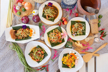 Som Tum Platter, A colorful selection of Thai papaya salads (Som Tum) served with salted egg, pork crackling, and traditional sides, capturing the heart of Thai street food.