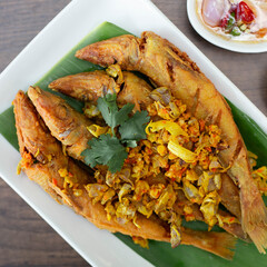 Turmeric Fried Fish: Golden yellow fried fish with distinct fish scales and sprinkled with...