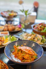 A close-up of a spicy crab curry served in a deep blue bowl, rich in coconut milk and aromatic spices, part of a traditional Thai seafood feast.