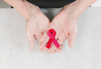 One red measuring tape in the palms of a woman.