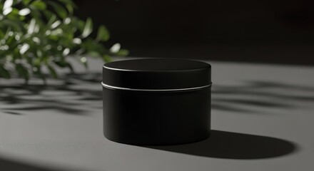 Premium mockup-style image of a black matte circular tin jar placed on a dark neutral surface