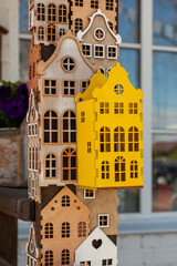 Decorative plywood houses are attached to a post, forming a whimsical and creative display