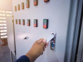 Electrical engineering is checking the electrical control panel by opening the panel cabinet lock.