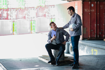 Tired freight supervisor resting briefly between shipment tasks. Great for content on employee...