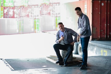 Moment of pause during warehouse operations. Logistics staff sitting down, reviewing tasks, and...