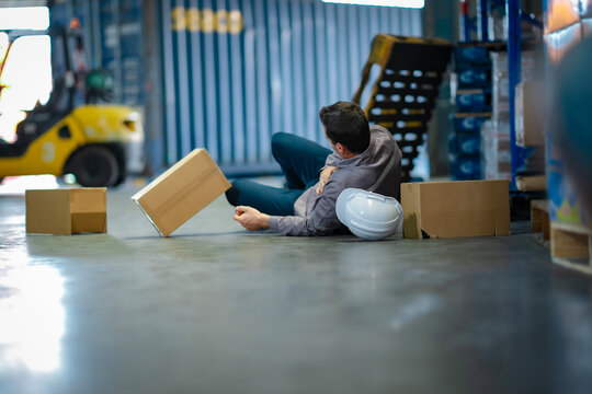 Logistics worker of older age fell while working. Realistic depiction of industrial hazards, warehouse injury, and employee well-being.