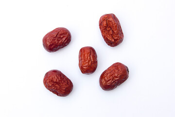 Red jujubes isolated on white background. Dried jujubes, also known as red dates, are a good source of fiber, which aids digestion and can help with weight management.