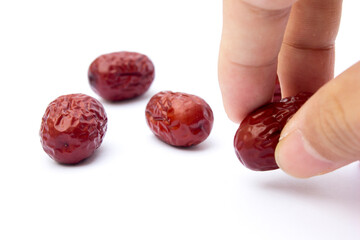 Red jujubes isolated on white background. Dried jujubes, also known as red dates, are a good source of fiber, which aids digestion and can help with weight management.