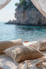 Obraz premium Close-up of cozy beach canopy bed with textured beige pillows and sheer curtains