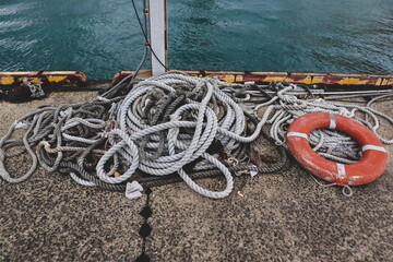 Coiled Mooring Ropes and Lifebuoy on Ship Dock – Nautical Safety Equipment