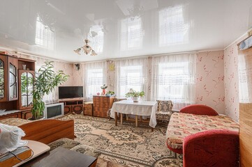traditionally decorated living room featuring floral wallpaper, a patterned carpet, multiple...
