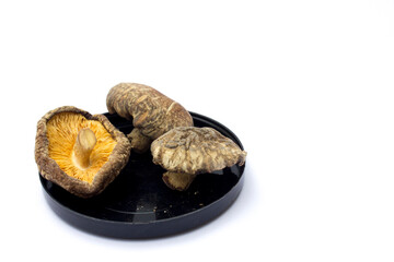 Dried shiitake mushrooms isolated on white background. They are a good source of vitamins, minerals, and antioxidants, and can potentially support immune function, heart health, and bone health.
