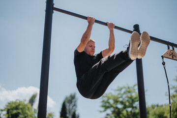A man demonstrating strength and fitness with outdoor calisthenics exercises in a park environment.