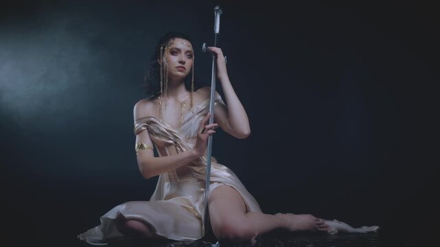 real person fashion model posing stong sad face eyes, fantasy woman queen holding sword in hands sitting on floor Black dark room full smoke night moon light fog. Gothic girl elf warrior. sharp blade