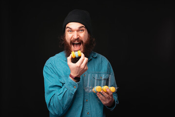 A joyful man eagerly bites into a colorful treat, showcasing enthusiasm and fun in a vibrant,...