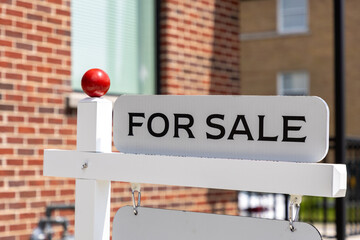 For sale sign in front of a residential building. Real estate market