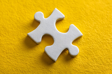 Obraz premium Missing puzzle piece on yellow background problem solving teamwork connection concept with copy space.