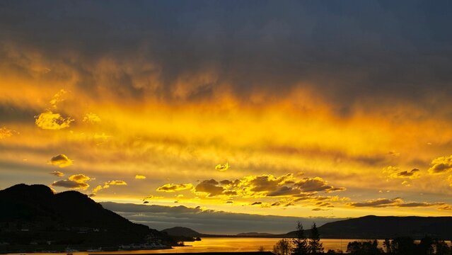 Dramatic golden sunset over Norwegian fjords and mountain 