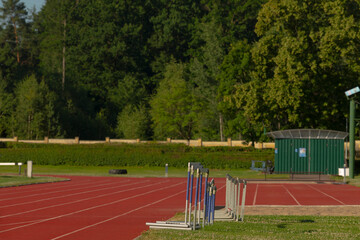 A running track that features a vibrant green building standing prominently in the background,...