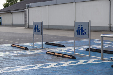 Spacious designated parking spots with blue ground markings and family stroller signs at an empty...
