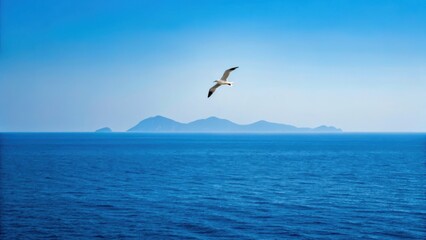 Naklejka premium A serene ocean scene with a bird soaring above calm waters and distant islands under a clear blue sky.