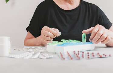 One woman places a tablet into a plastic container.