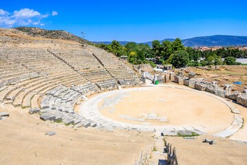 Stone amphitheater with a circular stage and stone wall surrounding it. Ruins of the ancient city...
