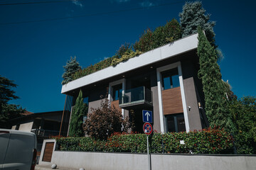 Stylish contemporary house surrounded by lush green foliage, featuring minimalist architecture and...