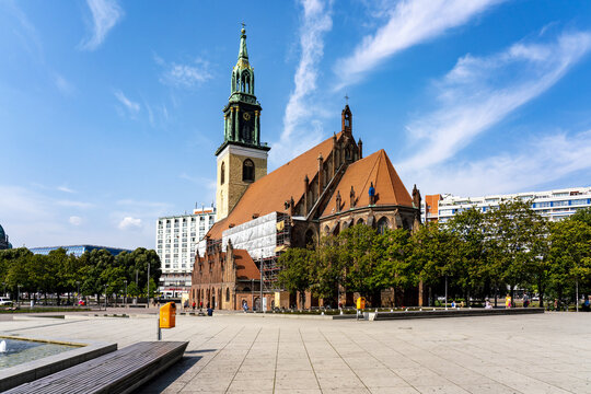 Berlin, Germany - 27 August 2019: View of the Marienkirche under a sky streaked with clouds, framed by the textures of stone and the urban landscape.