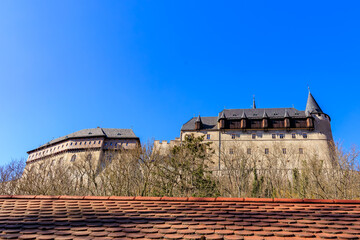 Historic castle with red tile roof under clear blue sky