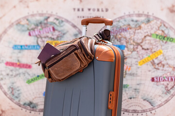 Modern travel suitcase with a brown leather waist bag and visible passport, placed in front of a...