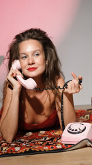 Portrait photo of happy smiling woman with bright makeup holding telephone receiver. Excited retro...