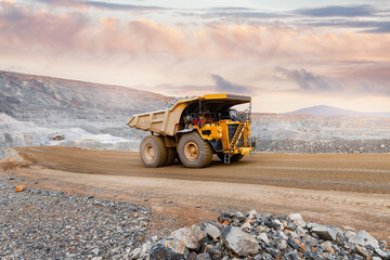 Big yellow mining truck transportation of gold ore. Open pit mine industry.
